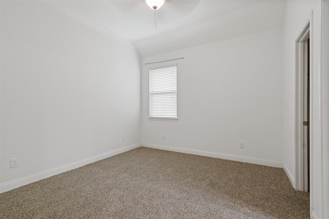 carpeted spare room featuring lofted ceiling, ceiling fan, and baseboards