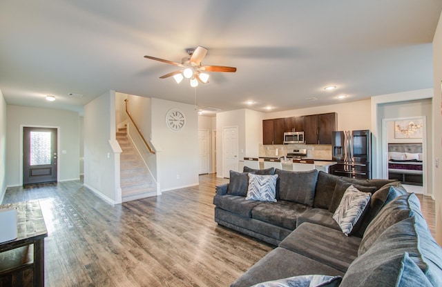 living room with ceiling fan and light hardwood / wood-style flooring