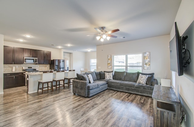 living room featuring ceiling fan and dark hardwood / wood-style flooring