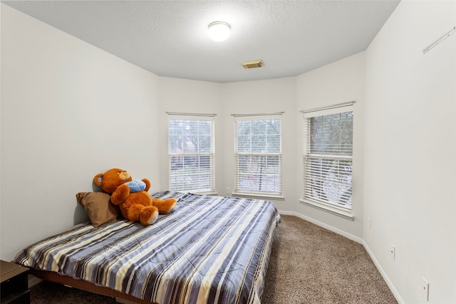 carpeted bedroom with a textured ceiling