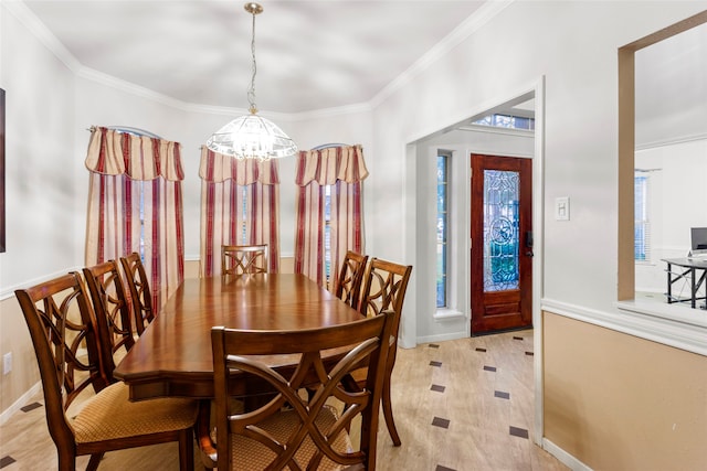 dining room with light hardwood / wood-style floors, crown molding, and a chandelier