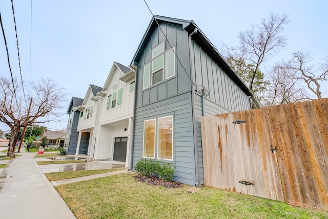 view of home's exterior with a garage and a lawn