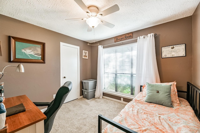 bedroom with ceiling fan, light colored carpet, multiple windows, and a textured ceiling