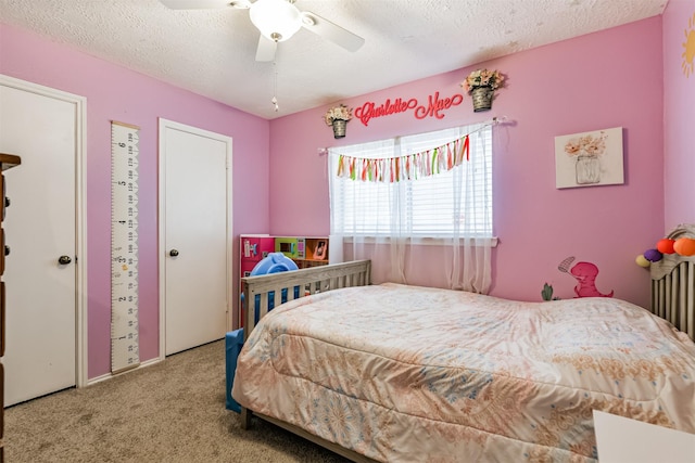 bedroom featuring a textured ceiling, ceiling fan, and carpet