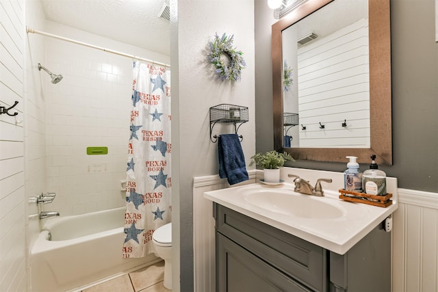 full bathroom featuring a textured ceiling, tile patterned flooring, vanity, toilet, and shower / bath combo