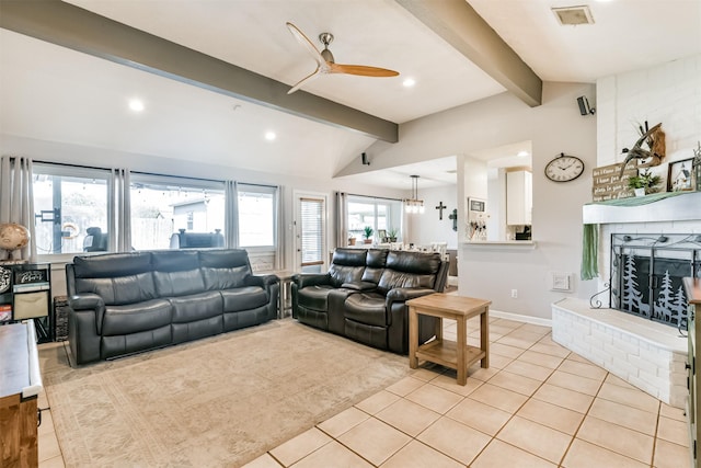 living room with ceiling fan, a healthy amount of sunlight, and vaulted ceiling with beams