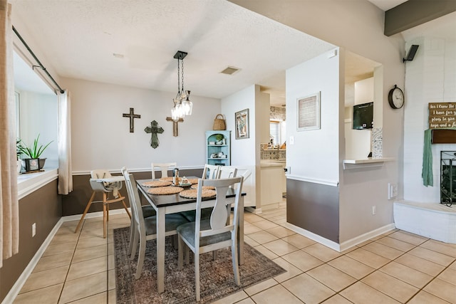 tiled dining room with a textured ceiling