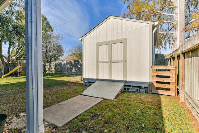 view of outdoor structure featuring a playground and a lawn