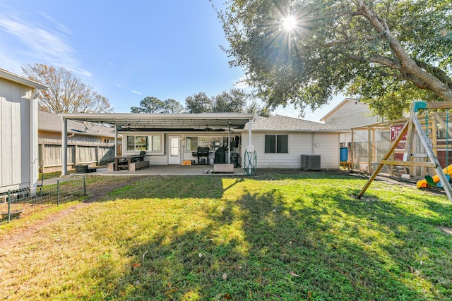 back of house with a patio area, a playground, a lawn, and central AC