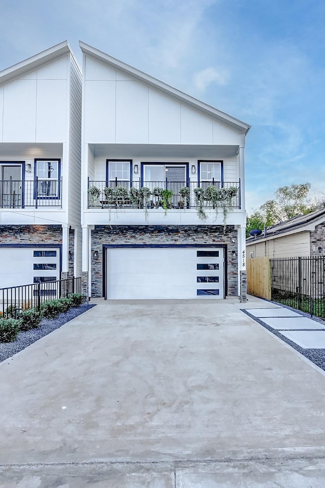 view of front of property featuring a balcony and a garage