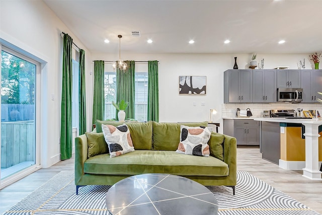 living room featuring a chandelier and light hardwood / wood-style flooring