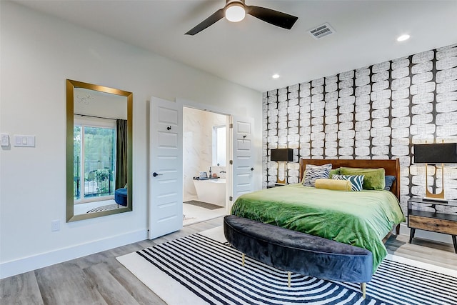 bedroom with ensuite bath, ceiling fan, and light hardwood / wood-style floors