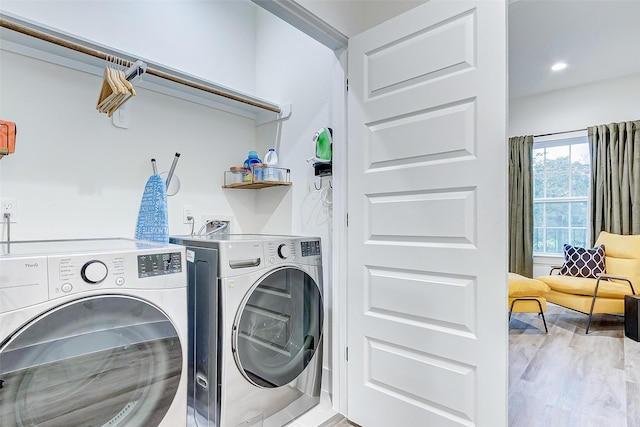 laundry area with light wood-type flooring and washer and dryer