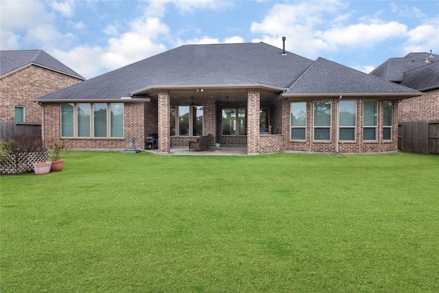 rear view of property featuring a yard and a patio