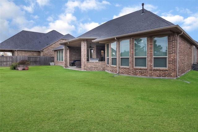 rear view of house featuring a patio area and a yard