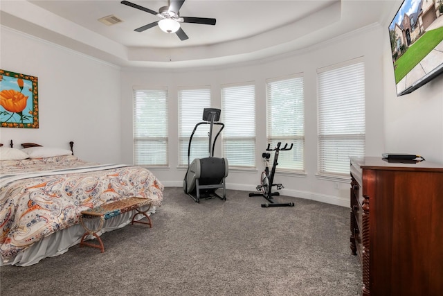 bedroom with ceiling fan, carpet, a tray ceiling, and ornamental molding