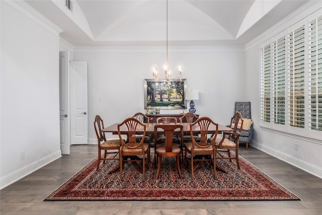 dining space with dark hardwood / wood-style flooring, crown molding, a chandelier, and vaulted ceiling