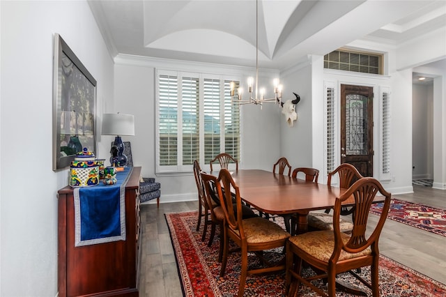 dining room with an inviting chandelier, ornamental molding, and dark hardwood / wood-style floors