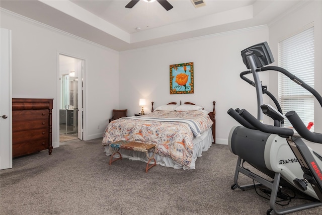 bedroom featuring ceiling fan, carpet, ensuite bath, crown molding, and a tray ceiling