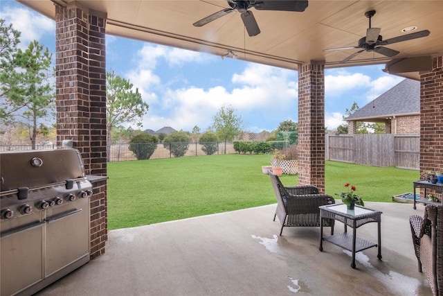 view of patio with ceiling fan, an outdoor kitchen, and a grill