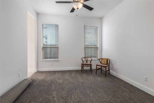 sitting room featuring ceiling fan and dark carpet