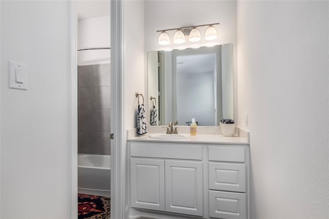 bathroom with tiled shower / bath and vanity