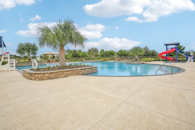 view of swimming pool featuring a gazebo, a patio area, and a water slide