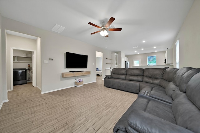 living room with ceiling fan and light hardwood / wood-style flooring