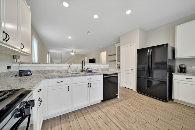 kitchen with white cabinetry, ceiling fan, black appliances, light stone counters, and sink