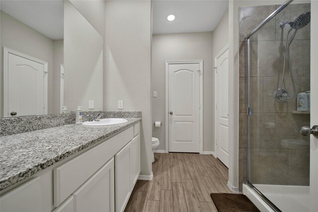 24715 Winema Woods Ln, Huffman, TX 77336 - bathroom featuring a shower stall, baseboards, toilet, wood finished floors, and vanity