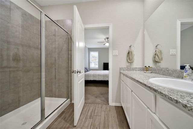 bathroom with ceiling fan, walk in shower, and vanity