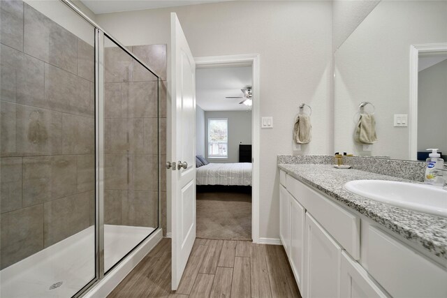 24715 Winema Woods Ln, Huffman, TX 77336 - ensuite bathroom with wood finished floors, a ceiling fan, a stall shower, and ensuite bathroom