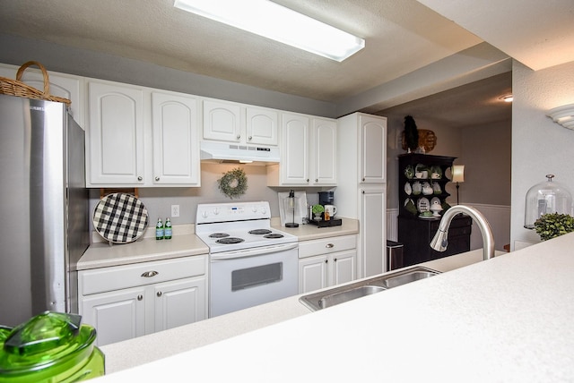 kitchen with white cabinetry, sink, electric range, and stainless steel fridge