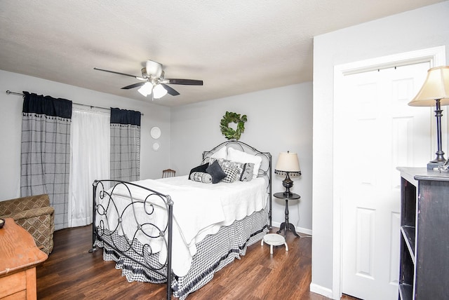 bedroom featuring dark wood-type flooring, ceiling fan, and a textured ceiling