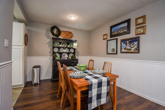 dining space with dark wood-type flooring and a textured ceiling