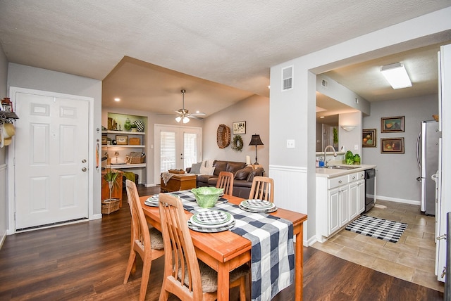 dining room featuring ceiling fan, dark hardwood / wood-style flooring, lofted ceiling, a textured ceiling, and sink