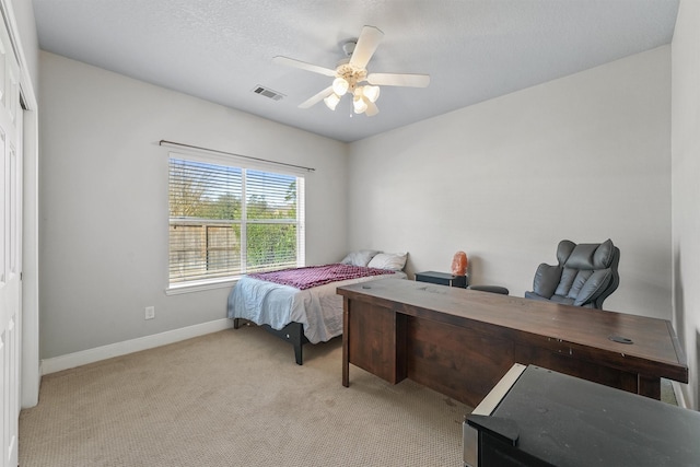 carpeted bedroom with a textured ceiling, ceiling fan, and a closet