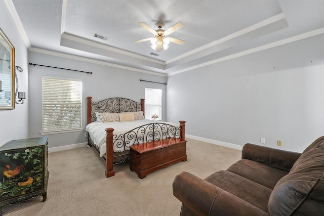 carpeted bedroom with ceiling fan, a textured ceiling, ornamental molding, and a raised ceiling