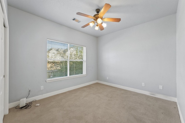 spare room featuring light carpet and ceiling fan