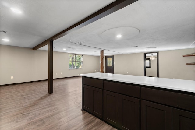 interior space featuring light wood-type flooring, a textured ceiling, and stainless steel fridge