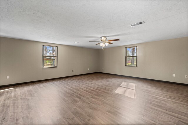 unfurnished room with ceiling fan, light hardwood / wood-style floors, and plenty of natural light