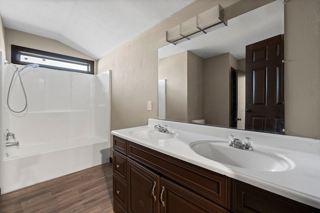 full bathroom featuring toilet, vanity, vaulted ceiling, hardwood / wood-style flooring, and shower / bathtub combination