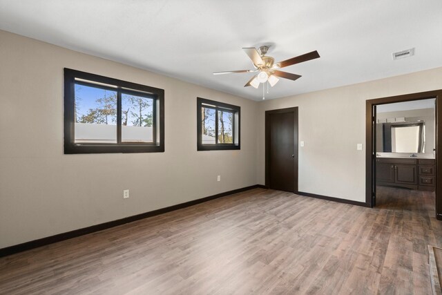 unfurnished bedroom with ceiling fan, light hardwood / wood-style floors, and ensuite bath