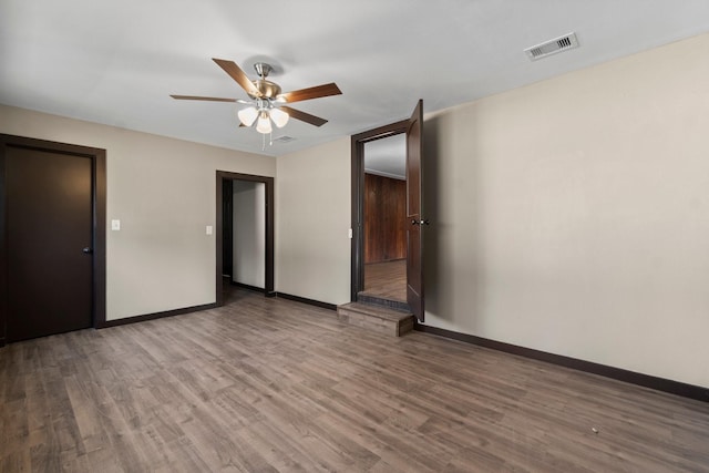 empty room with hardwood / wood-style flooring and ceiling fan