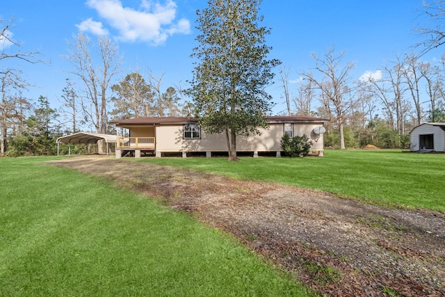 back of house featuring a lawn and a carport