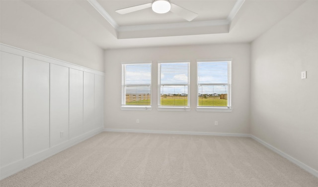 unfurnished room featuring light carpet, ceiling fan, crown molding, and a tray ceiling