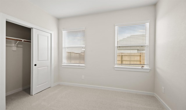 unfurnished bedroom featuring a closet and light carpet