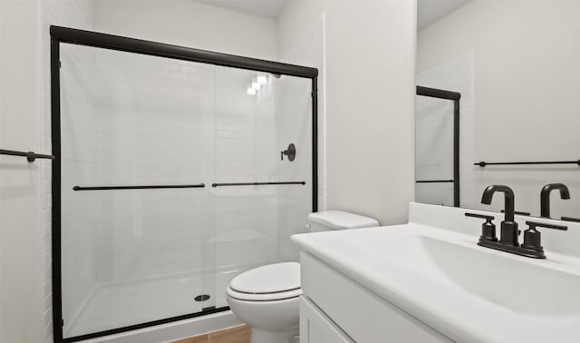 bathroom with toilet, walk in shower, and vanity