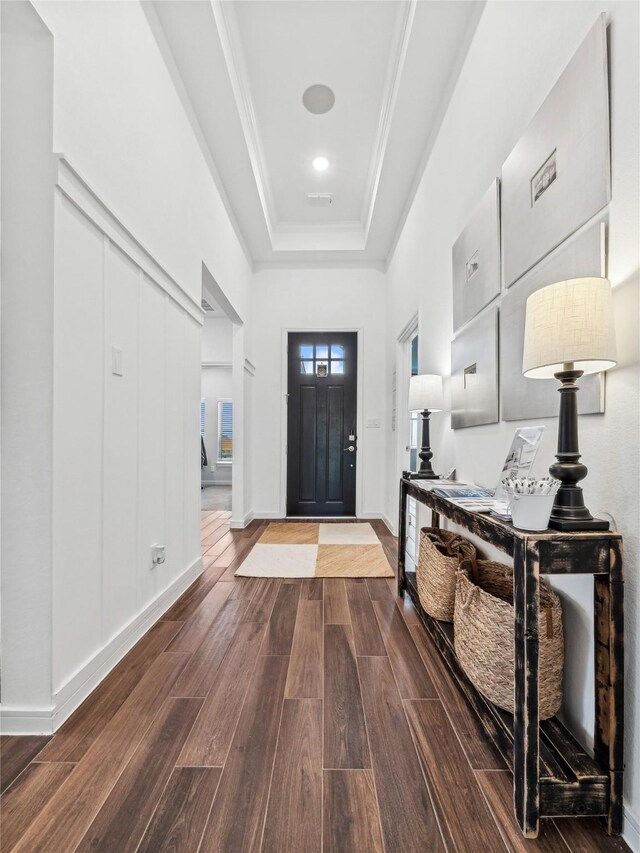 foyer entrance featuring a tray ceiling and ornamental molding