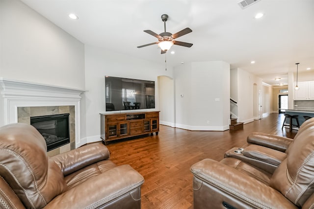 living room with ceiling fan, dark wood-type flooring, and a fireplace